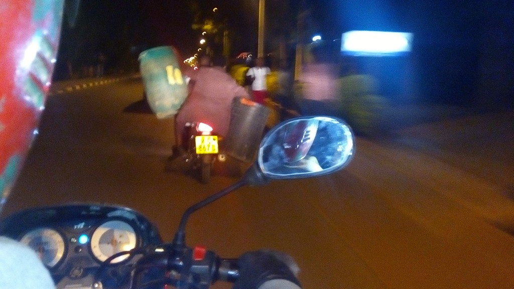 Captured while riding on a moto  in Kigali one Friday night. Carrying 2 drums on a moto takes serious skills.